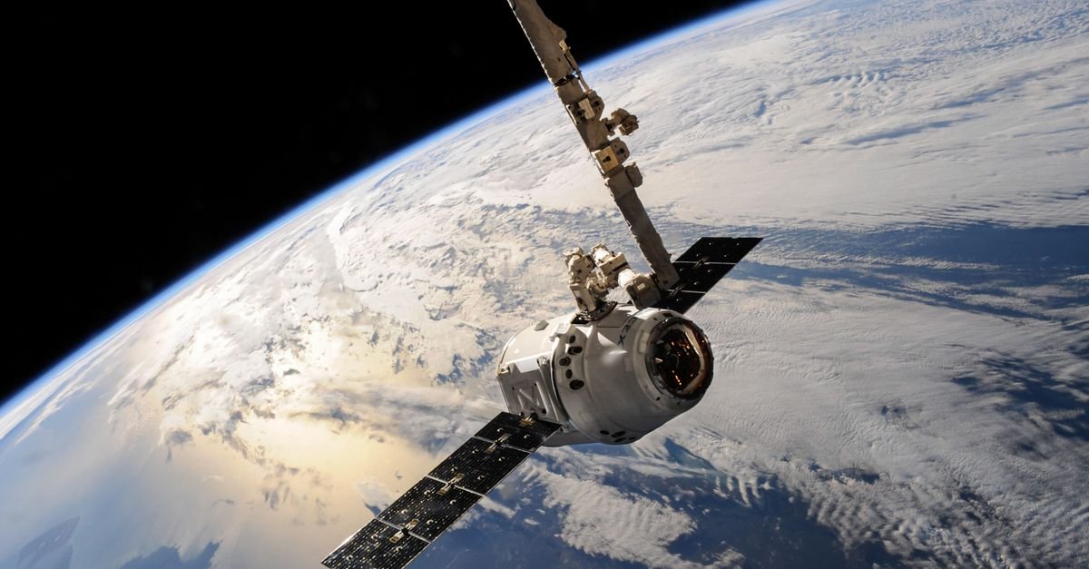 Satélite em órbita sobre a Terra, com painéis solares abertos e nuvens ao fundo