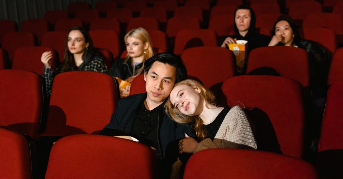 Público sentado em poltronas vermelhas de sala de cinema