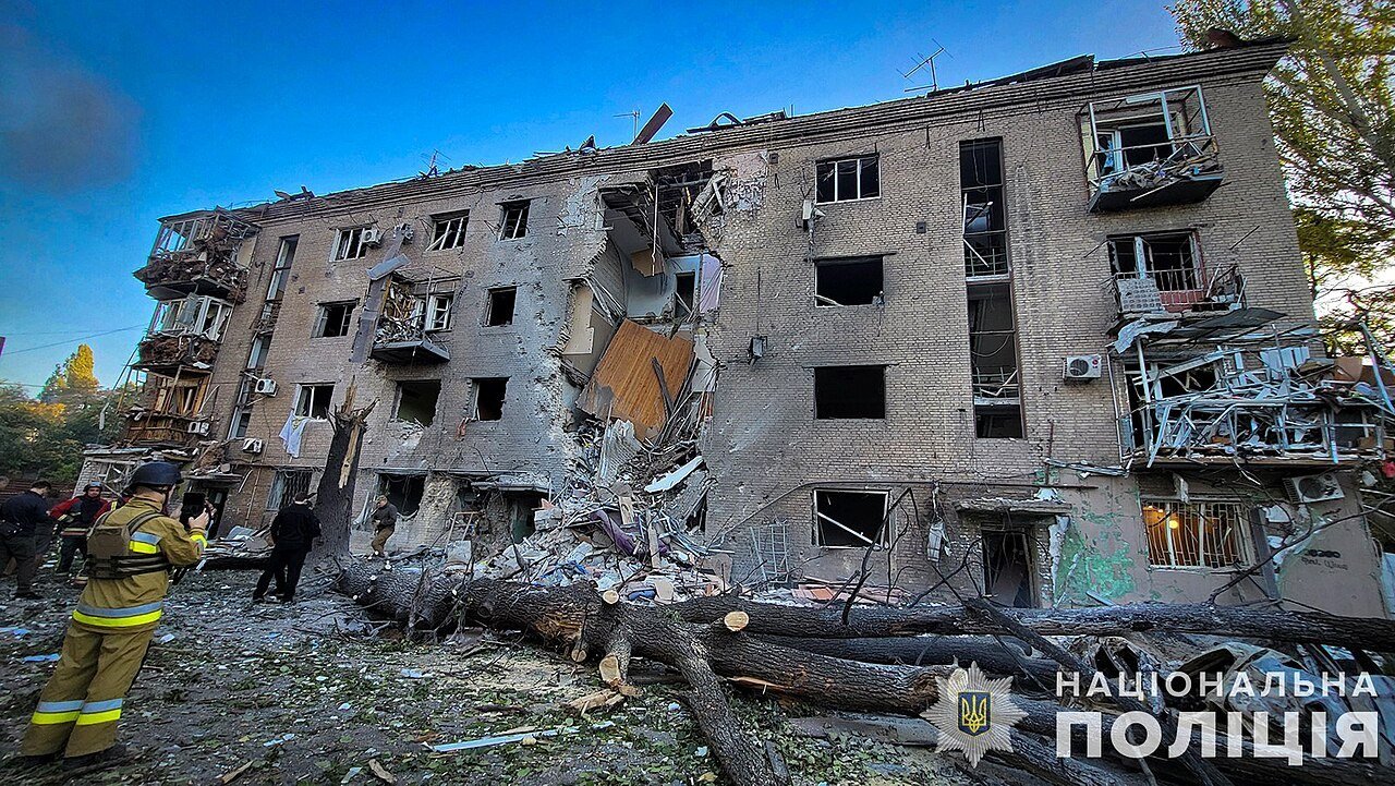 Prédio de apartamentos danificado por ataque russo em Zaporizhzhia, com bombeiro ao lado dos escombros, em foto de arquivo de setembro de 2024