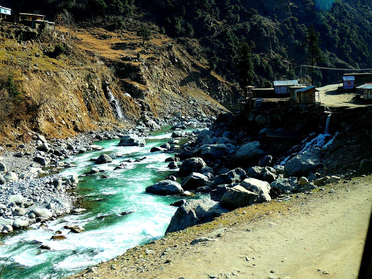 Vista do rio que corta o vale do Swat, no noroeste do Paquistão, com montanhas e casas ao fundo