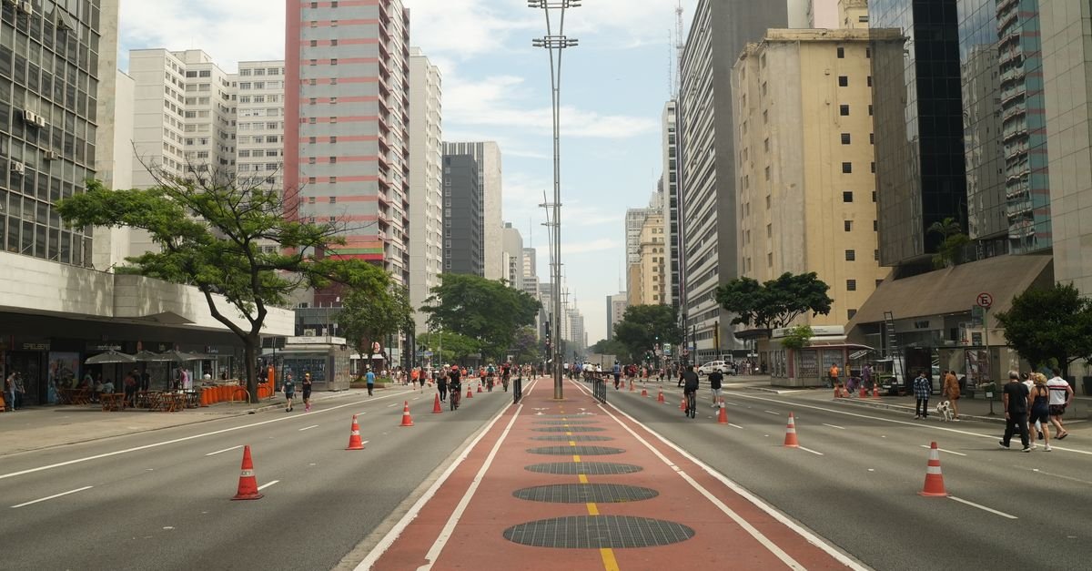 Avenida Paulista, em São Paulo, com pedestres e ciclistas em dia de sol