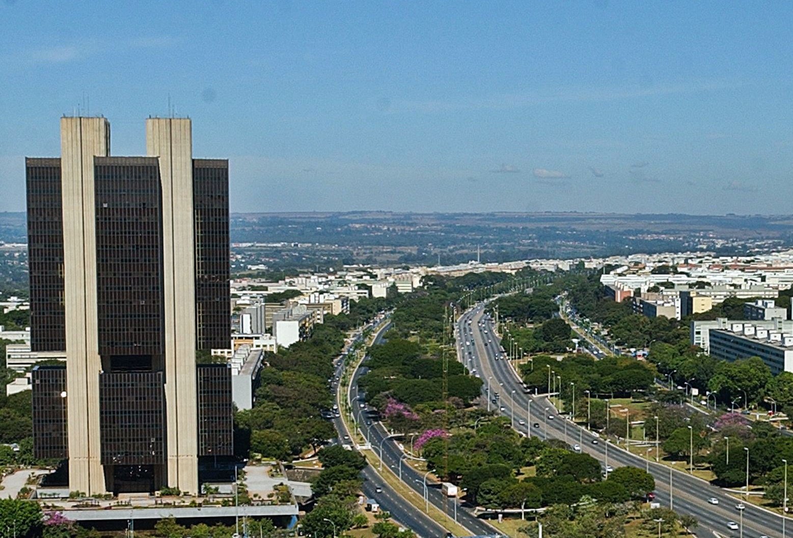 Edifício-sede do Banco Central do Brasil visto do alto, com o Eixo Rodoviário de Brasília ao fundo