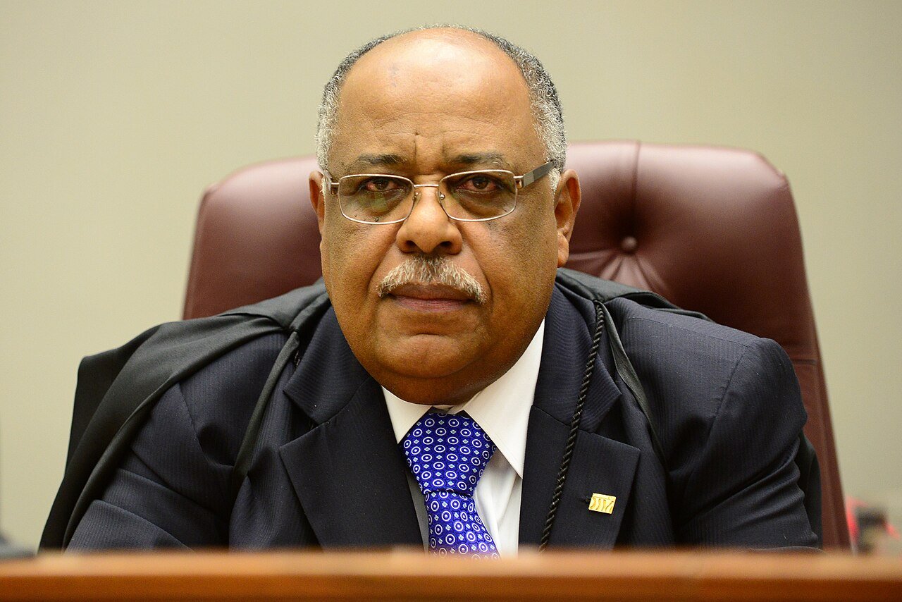 Ministro Benedito Gonçalves, de toga, sentado à bancada de julgamento