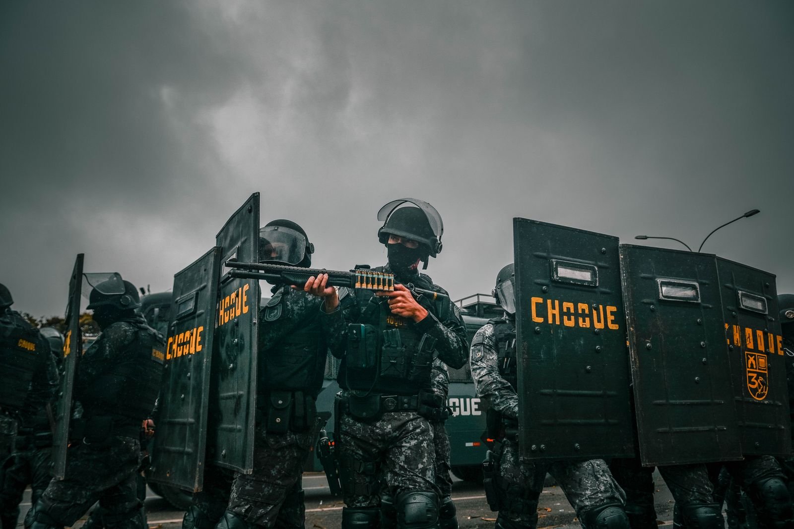 Policiais em equipamento tático de tropa de choque com escudos (imagem ilustrativa)