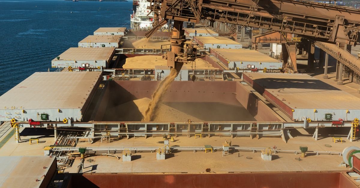 Vista aérea de navio graneleiro sendo carregado com grãos em terminal portuário