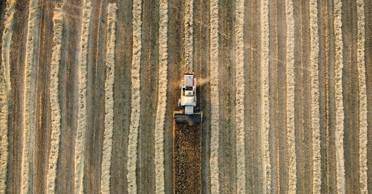 Vista aérea de colheitadeira em lavoura durante a colheita