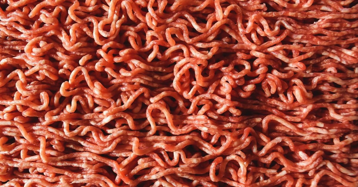 Carne bovina moída crua vista de perto, ocupando todo o quadro