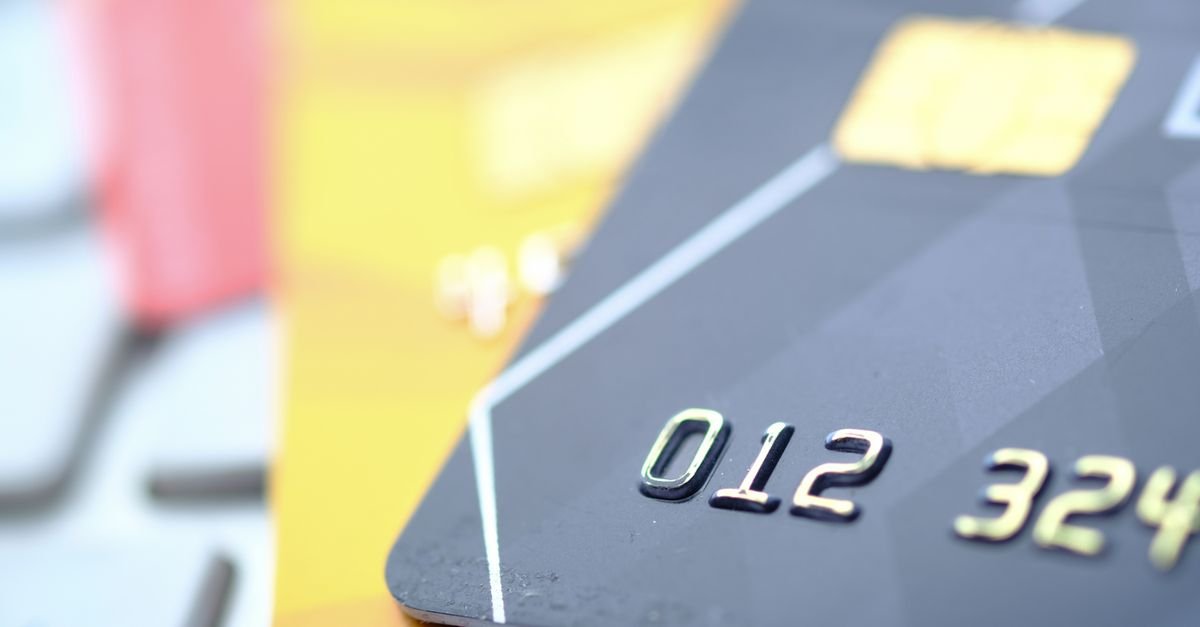 Close de cartões bancários empilhados, com números em relevo e chip dourado