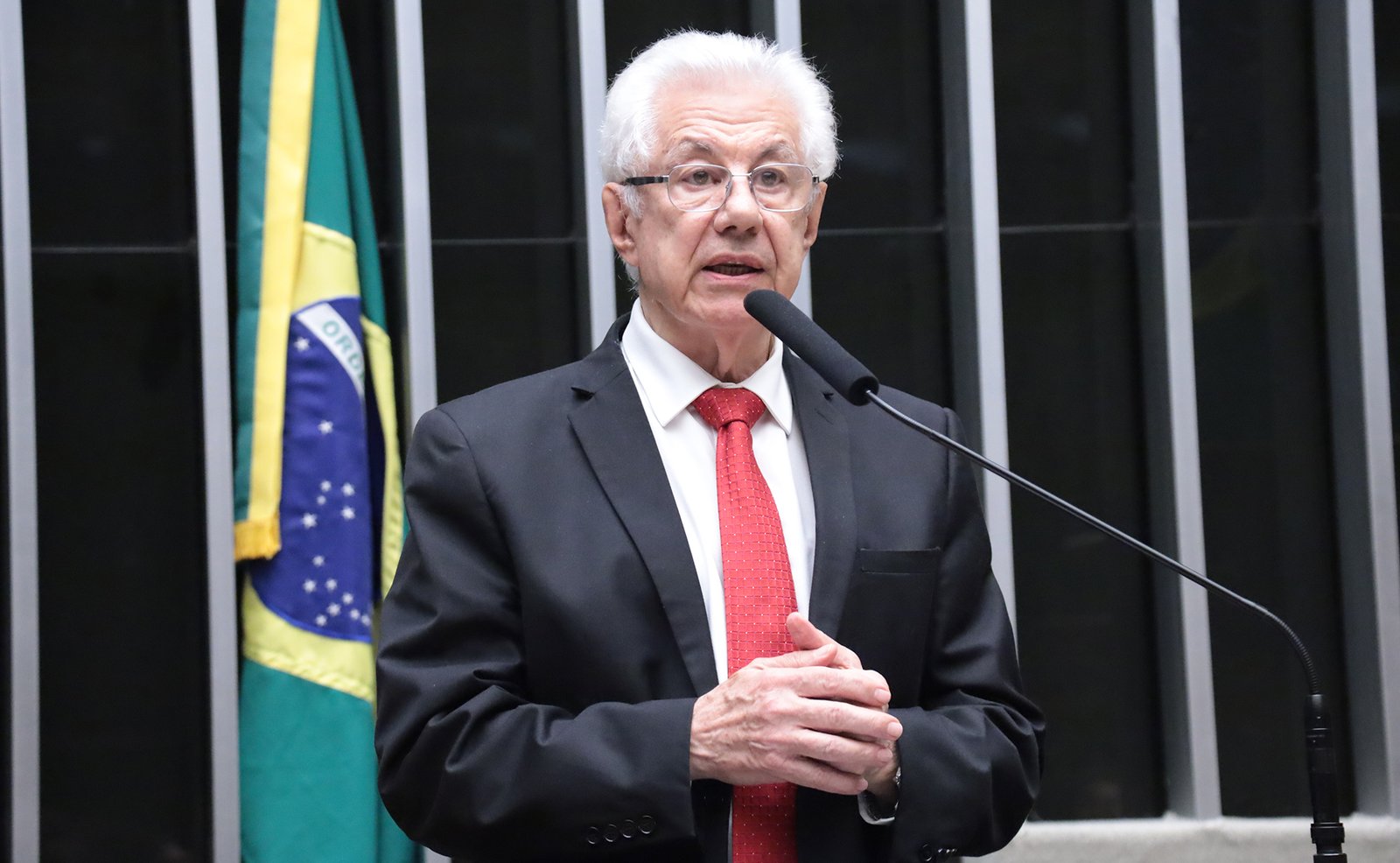 O deputado Arlindo Chinaglia (PT-SP) discursa no plenário da Câmara dos Deputados, ao lado da bandeira do Brasil