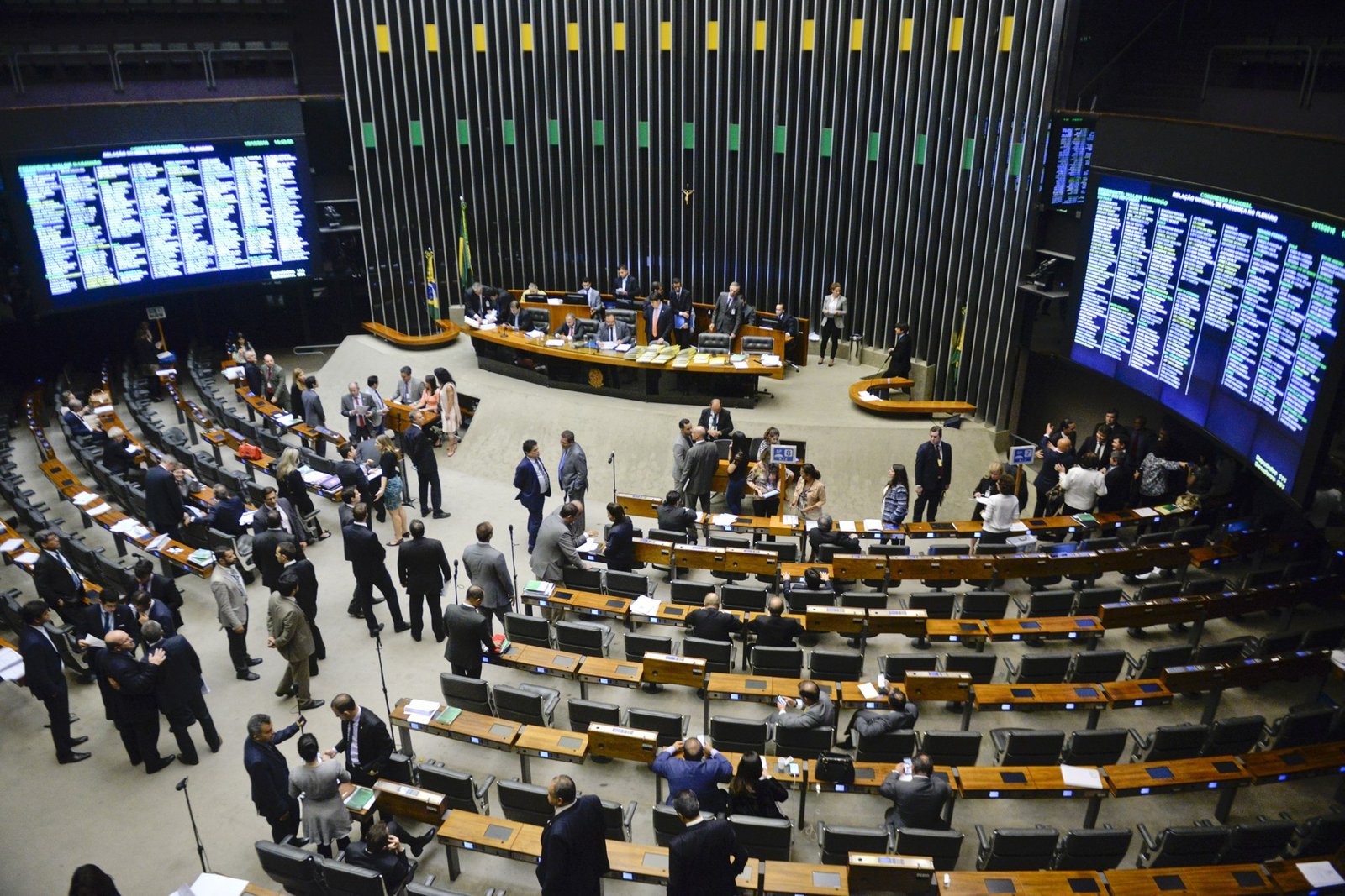 Plenário da Câmara dos Deputados em sessão do Congresso Nacional, com parlamentares em conversa e os painéis de presença ao fundo; foto de arquivo