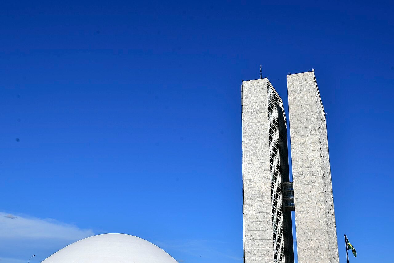 Torres e cúpula do Congresso Nacional, em Brasília, vistas de baixo com céu azul