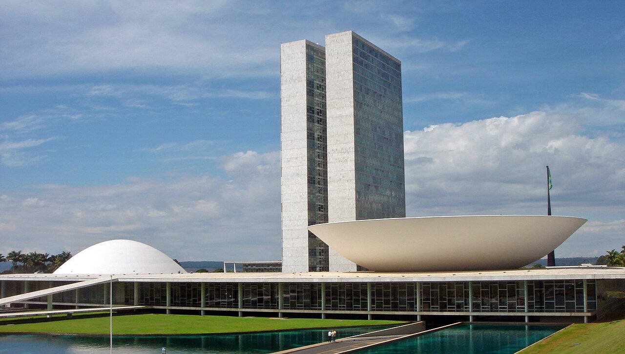 Vista do Congresso Nacional em Brasília, com as duas torres, a cúpula do Senado e o plenário da Câmara em dia de céu azul