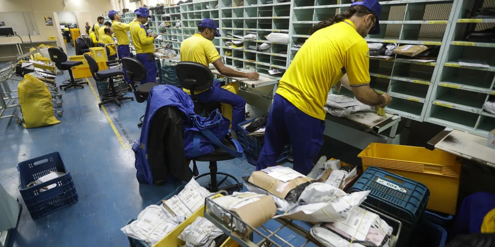 Empregados dos Correios separam encomendas em unidade de distribuição