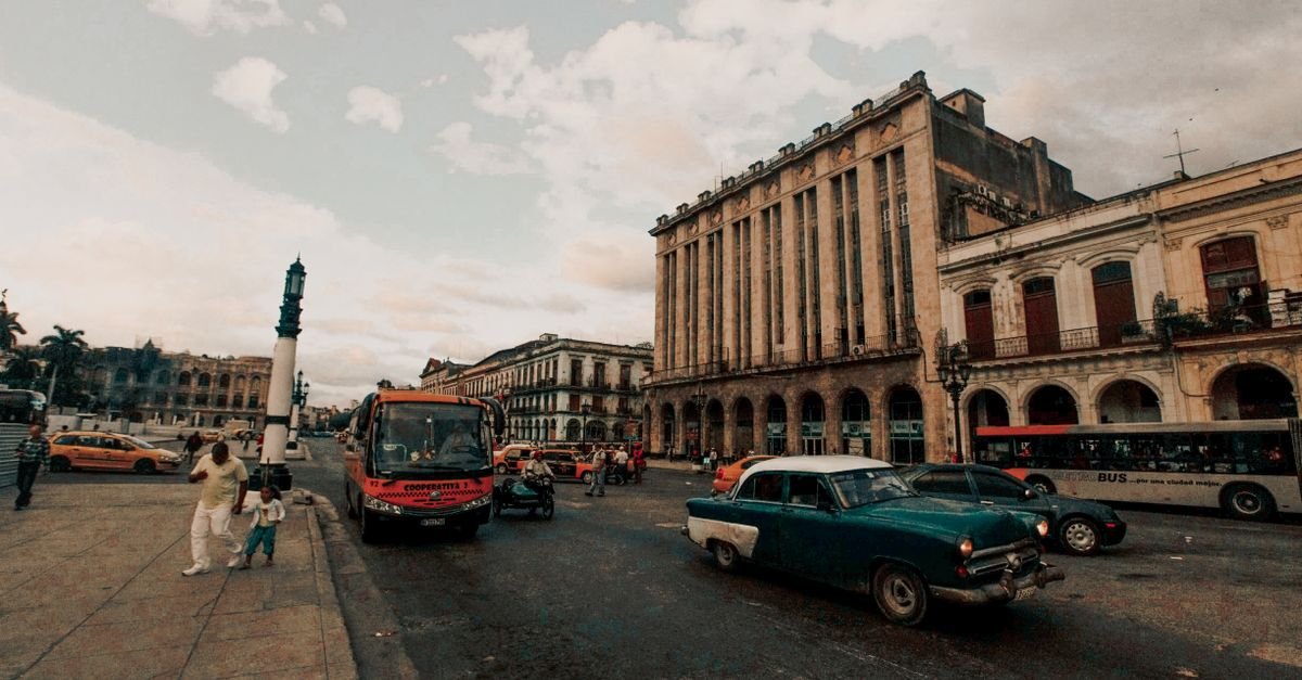 Rua de Havana com carros antigos e prédios de arquitetura colonial ao entardecer