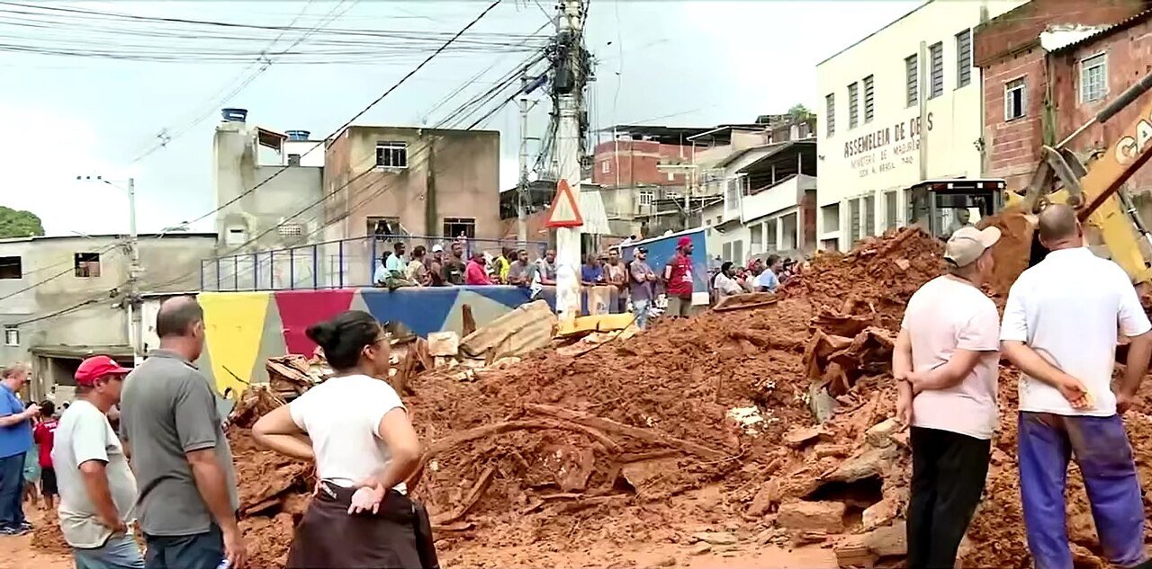 Moradores observam deslizamento de terra em rua de cidade da Zona da Mata mineira