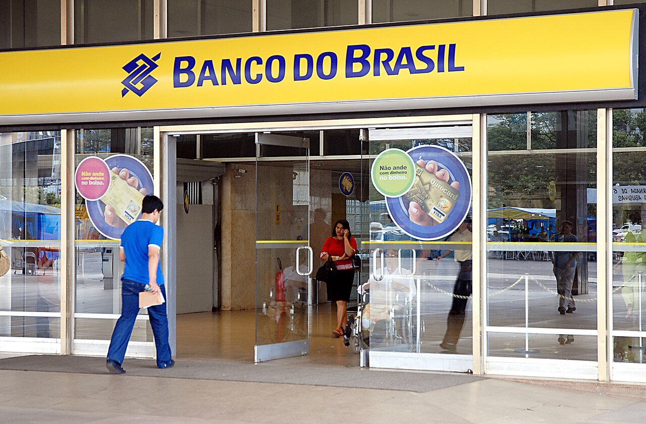 Fachada de agência do Banco do Brasil com clientes entrando e saindo