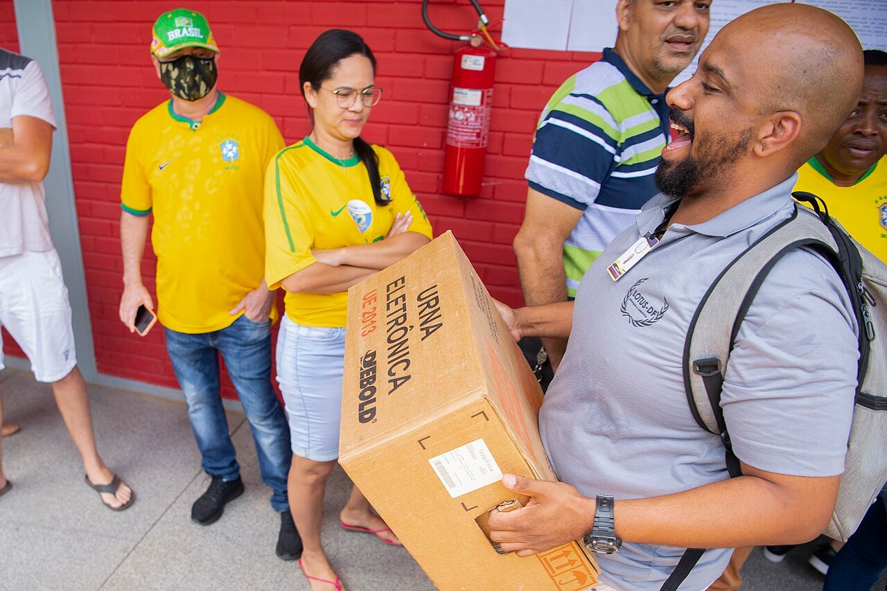 Funcionário carrega caixa de urna eletrônica em seção eleitoral, em foto de arquivo