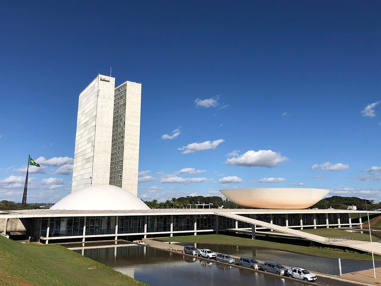 Fachada do Congresso Nacional em Brasília, com as torres, as cúpulas e a bandeira do Brasil hasteada