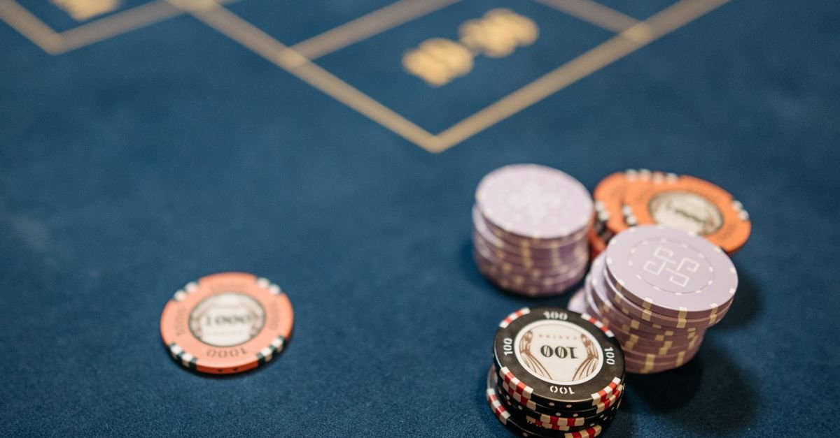 Fichas de aposta empilhadas sobre mesa de feltro azul em close