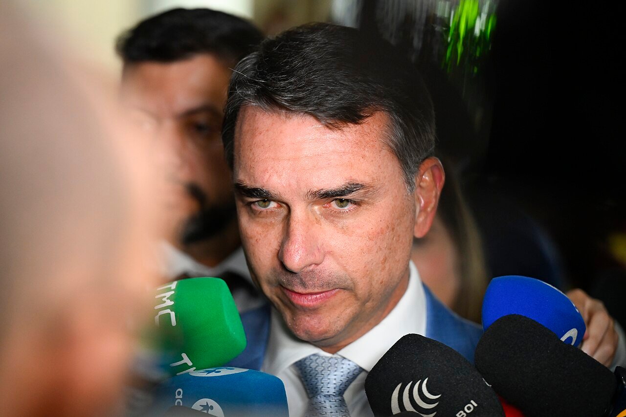 O senador Flávio Bolsonaro dá entrevista cercado por microfones de emissoras