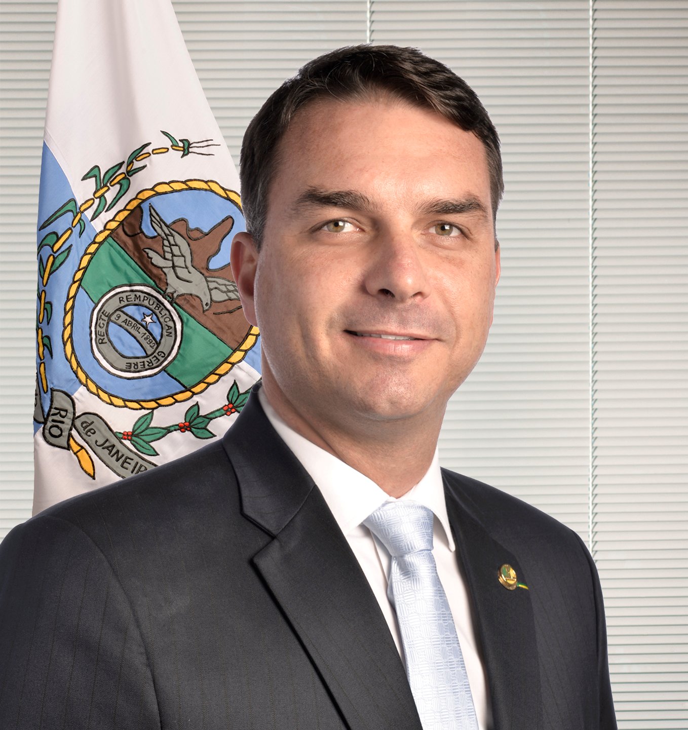Retrato oficial do senador Flávio Bolsonaro (PL-RJ) diante da bandeira do Rio de Janeiro