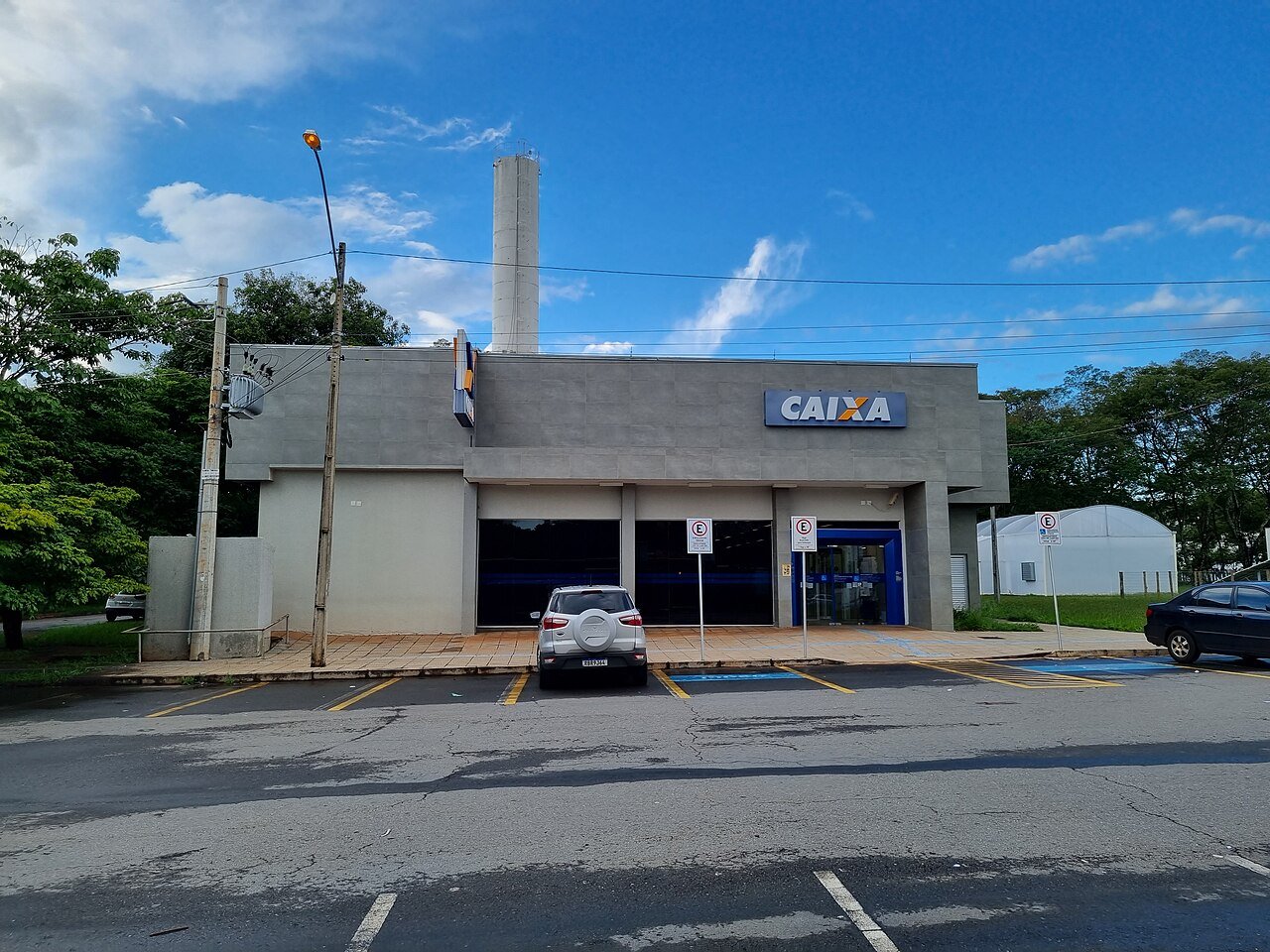 Fachada de agência da Caixa Econômica Federal com estacionamento vazio