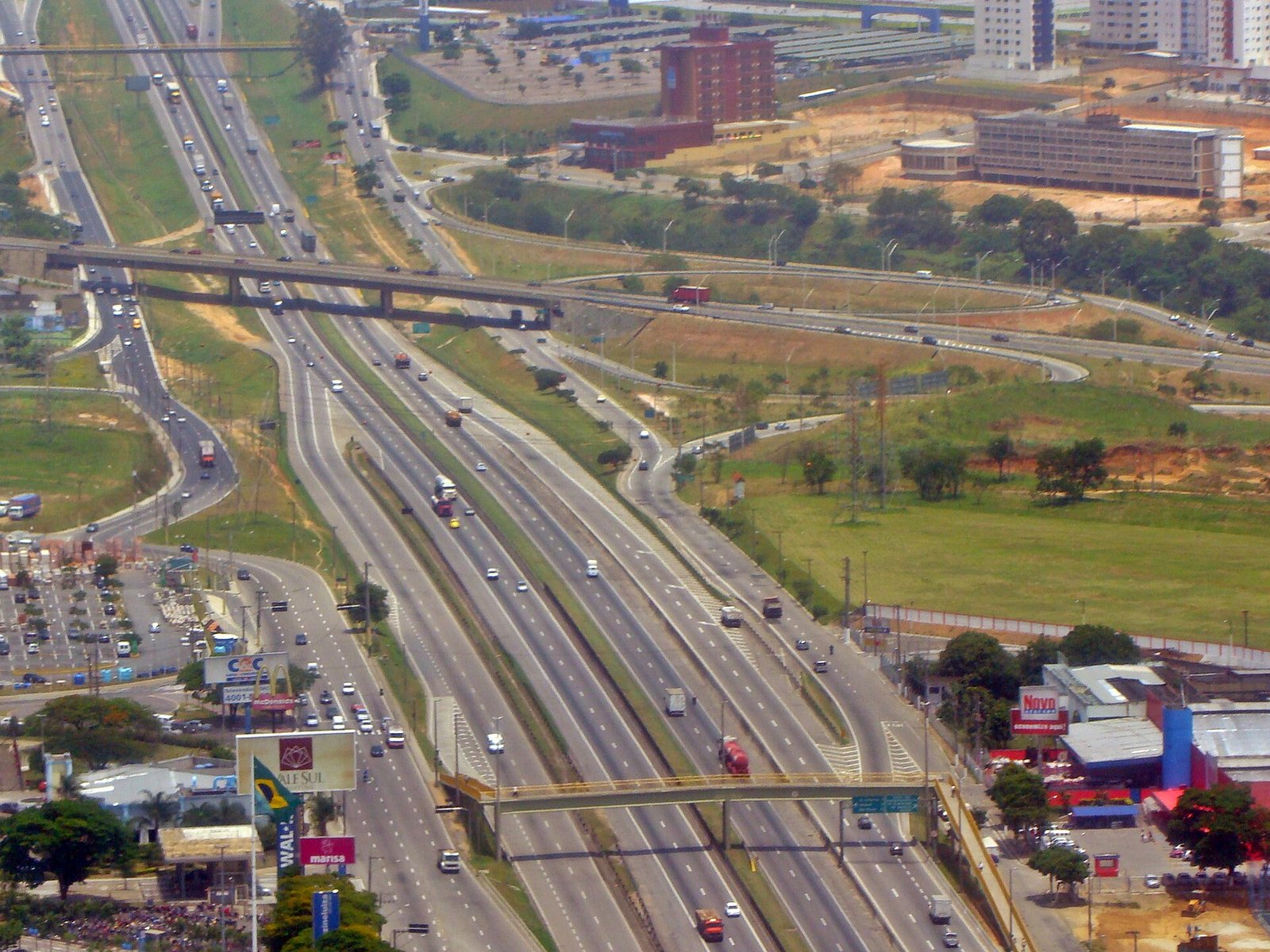 Vista aérea de rodovia com viadutos, prédios e comércio em cidade brasileira