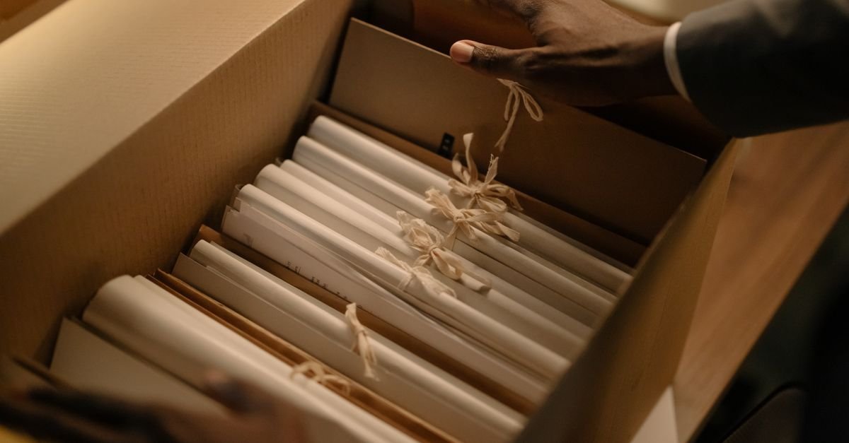 Caixa com processos e documentos amarrados sendo manuseada