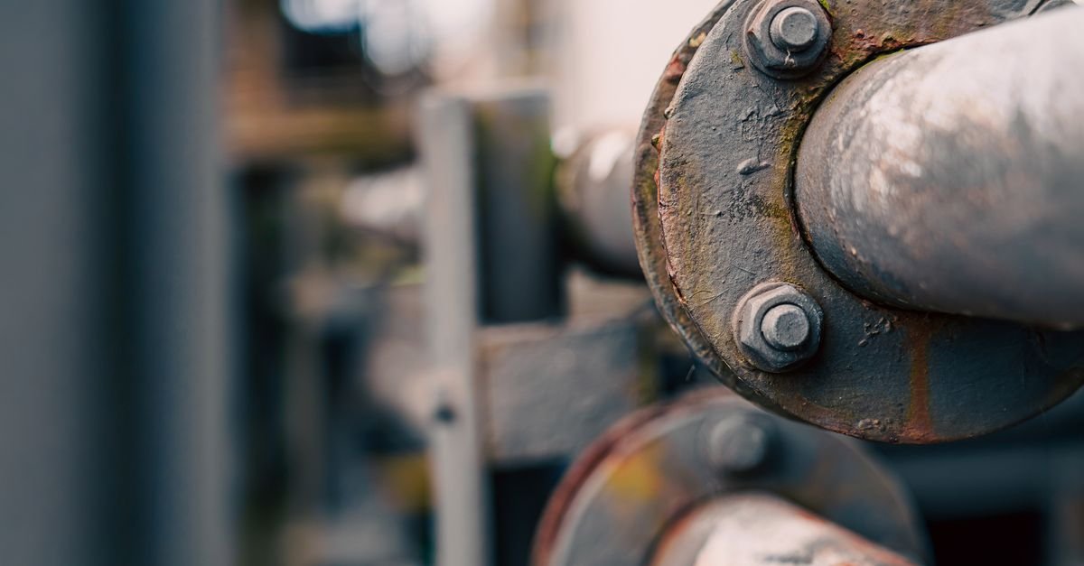 Tubulacao industrial de gas em closeup, com flange e parafusos
