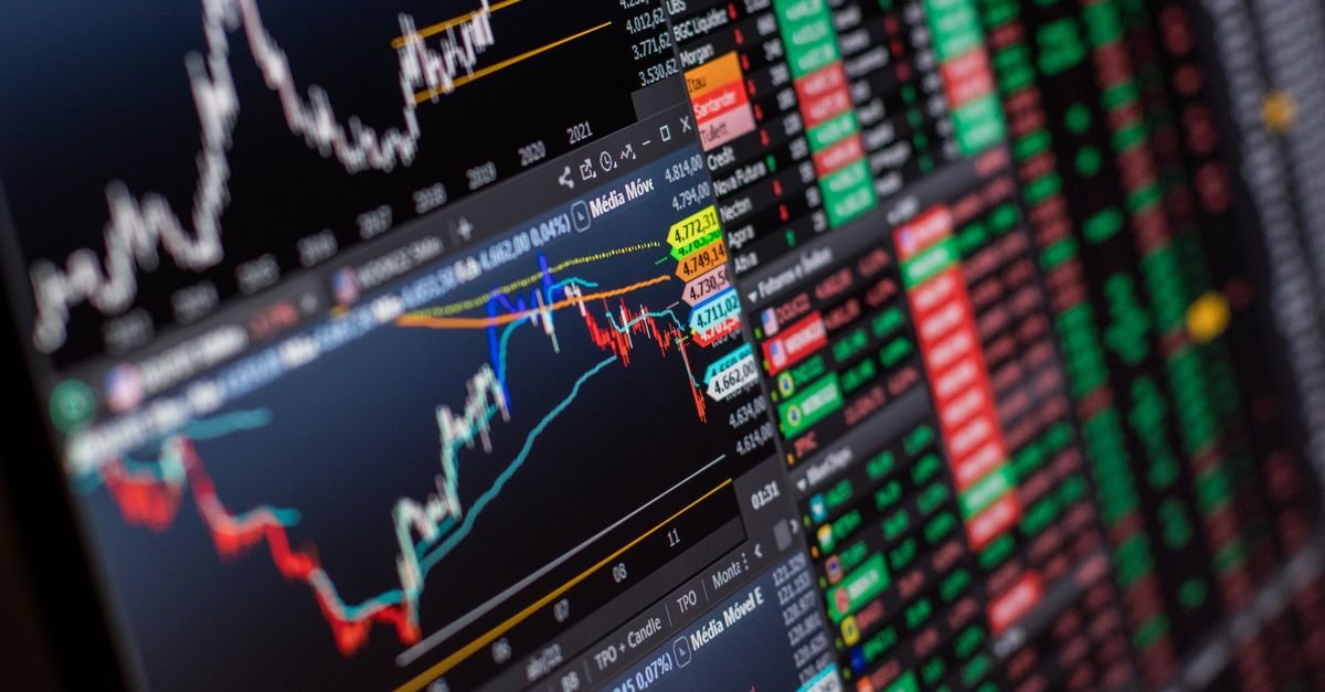 Tela de plataforma de negociação com gráficos de candles e cotações do mercado brasileiro