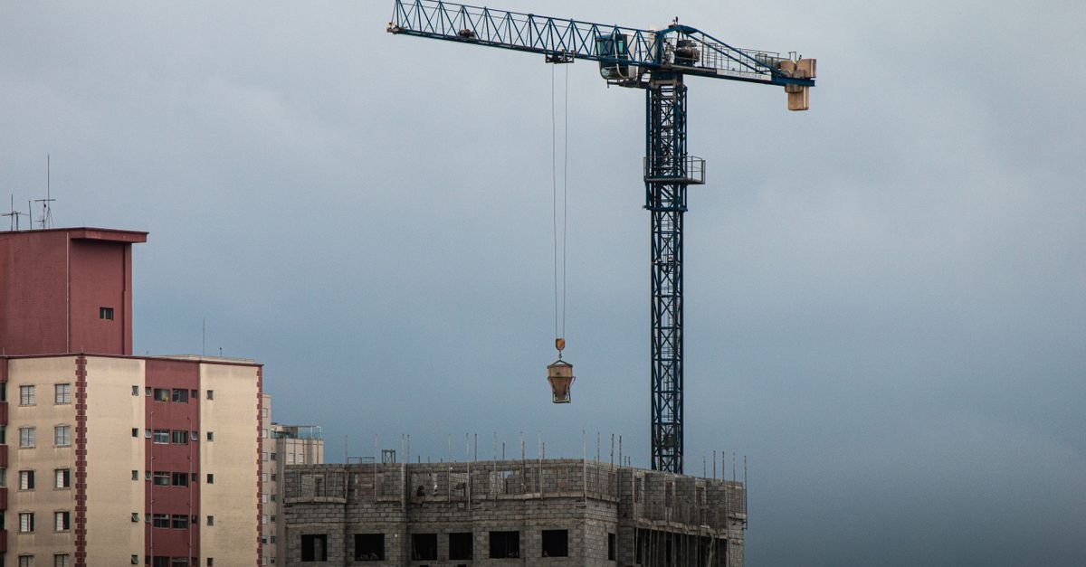 Guindaste de torre sobre predio em construcao em area urbana