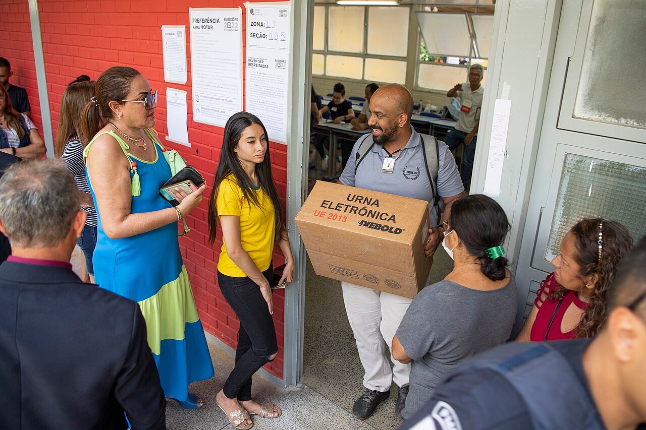 Mesário carrega caixa com urna eletrônica em seção eleitoral, em foto de arquivo do segundo turno de 2022