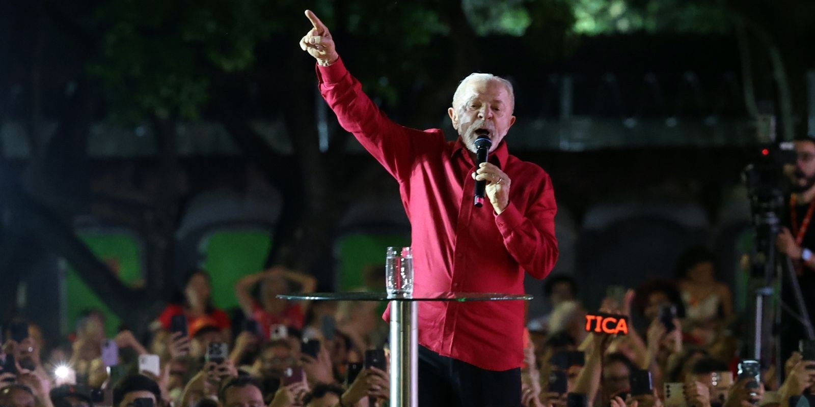 Luiz Inácio Lula da Silva discursa com microfone diante de público