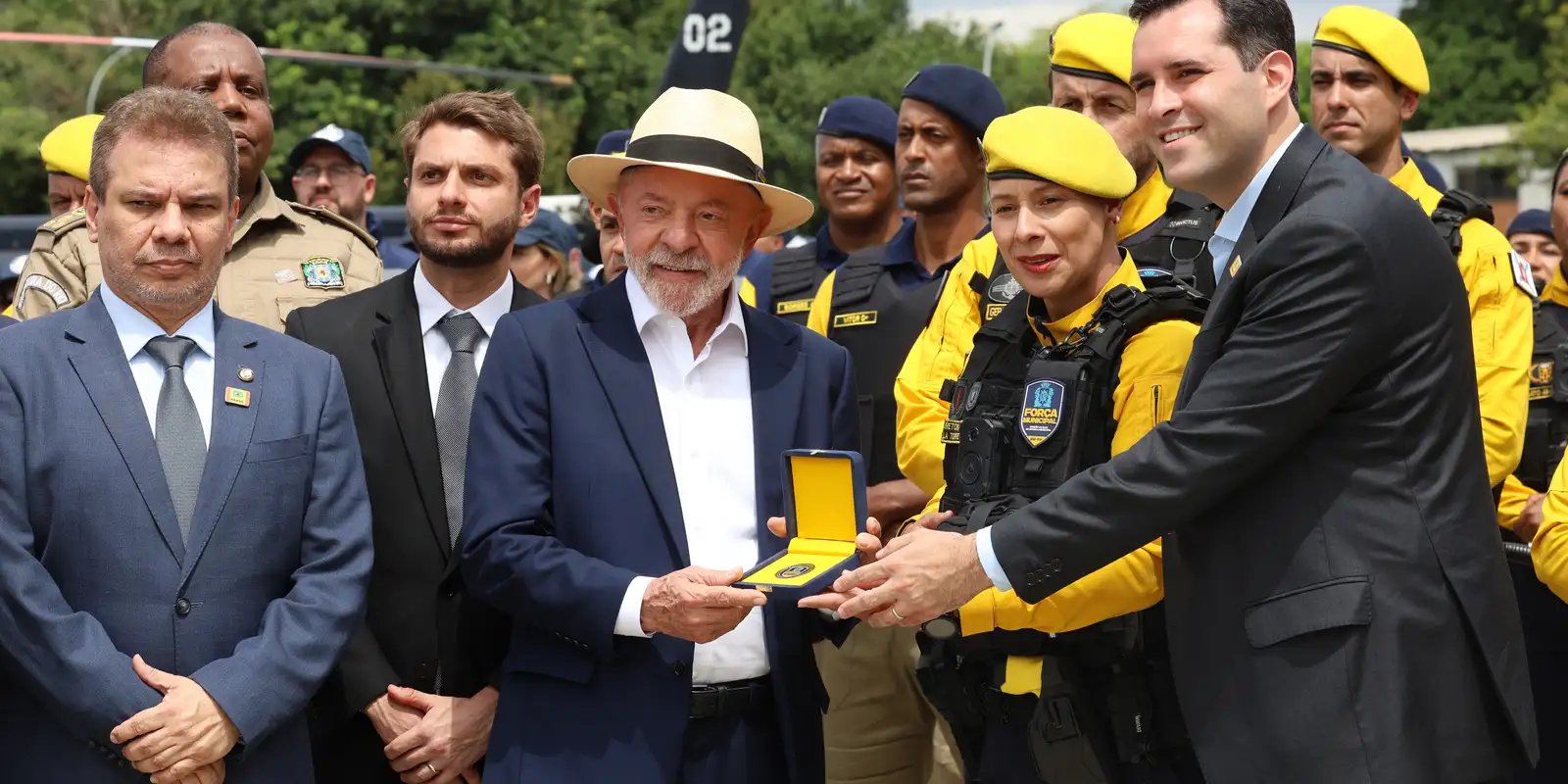 Presidente Luiz Inácio Lula da Silva recebe uma medalha em evento com agentes de segurança uniformizados