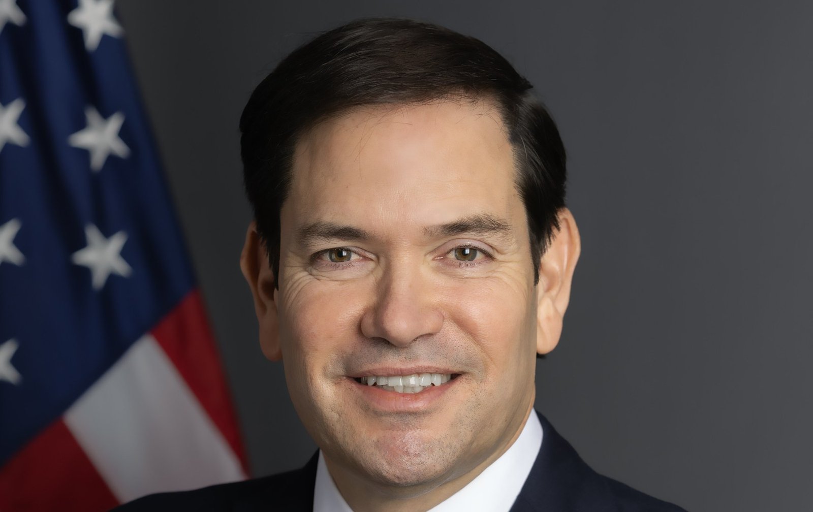 O secretário de Estado dos EUA, Marco Rubio, em retrato oficial diante da bandeira americana