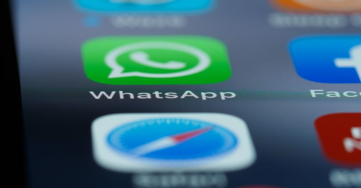 Ícone do WhatsApp em close na tela de um celular, com outros aplicativos desfocados