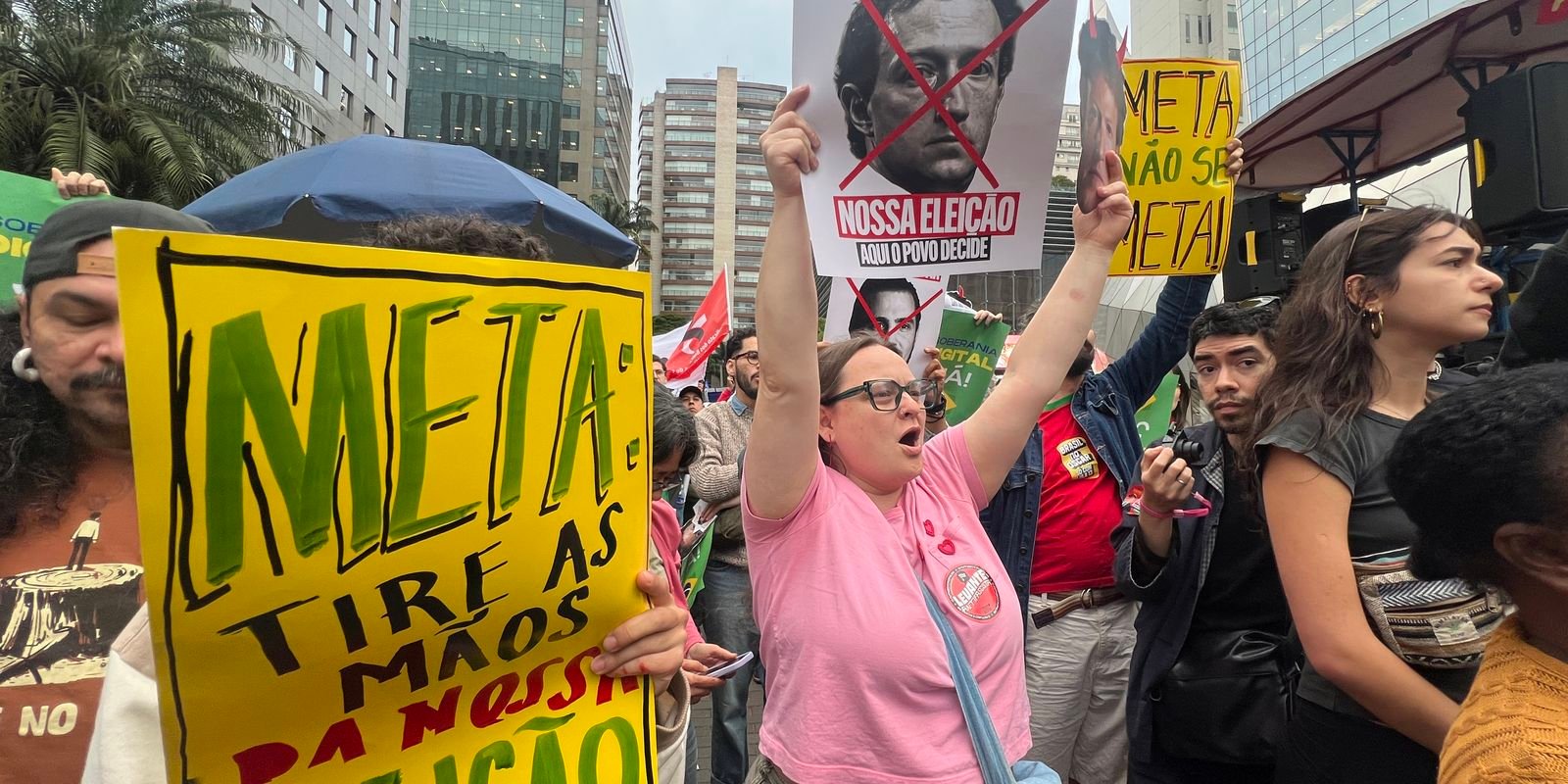 Manifestantes com cartazes contra a Meta em protesto na região da avenida Faria Lima, em São Paulo