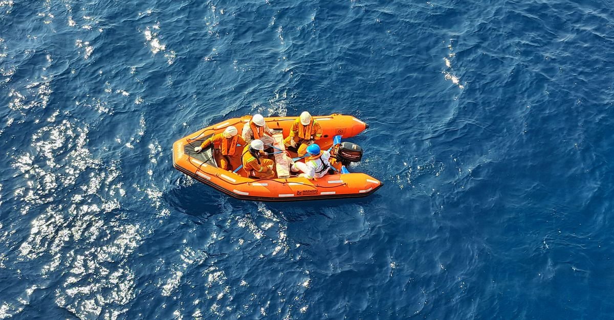 Bote laranja de equipe de resgate navegando em mar aberto