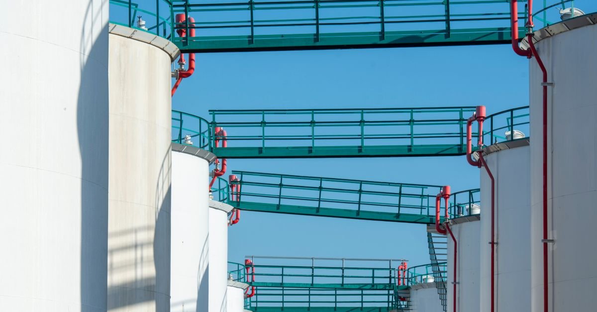 Tanques de armazenamento de combustível alinhados sob céu azul