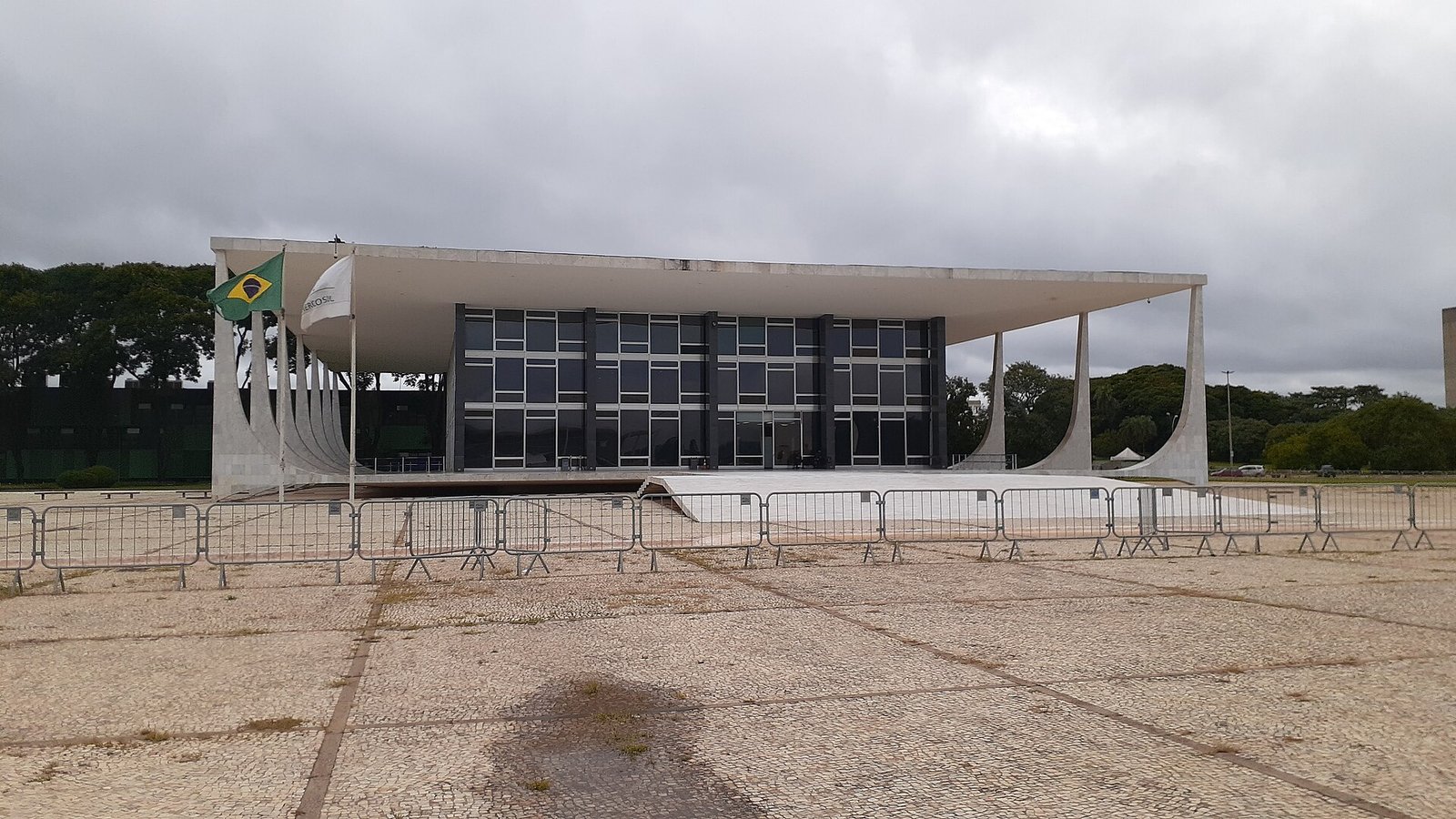 Fachada do Palácio do Supremo Tribunal Federal, em Brasília, com bandeira do Brasil e grades de contenção