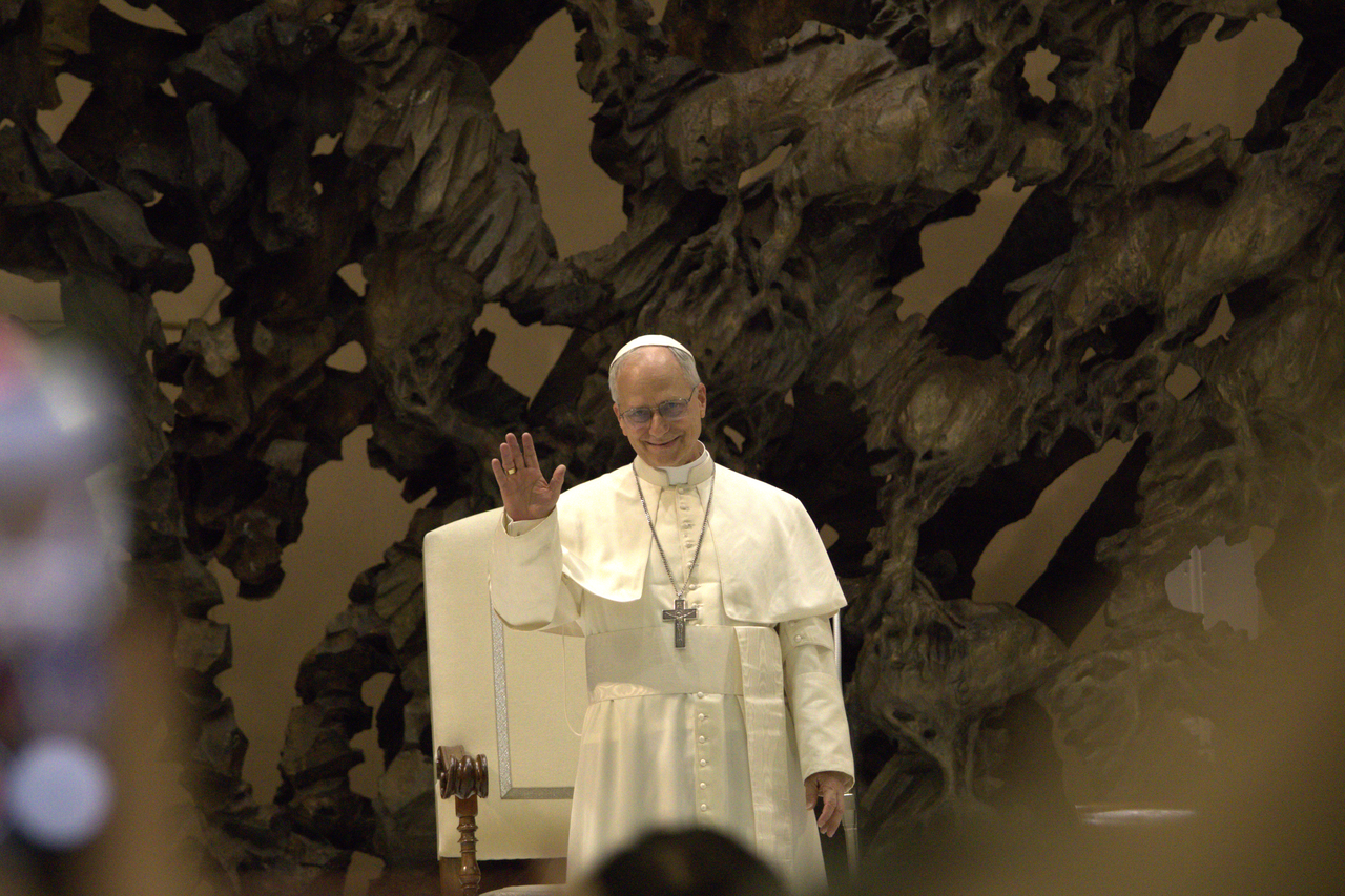 O papa Leão XIV de vestes brancas acena para os fiéis