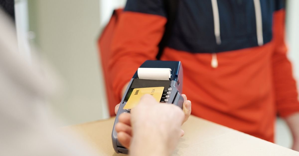 Cliente insere cartão em terminal de pagamento em balcão de estabelecimento comercial