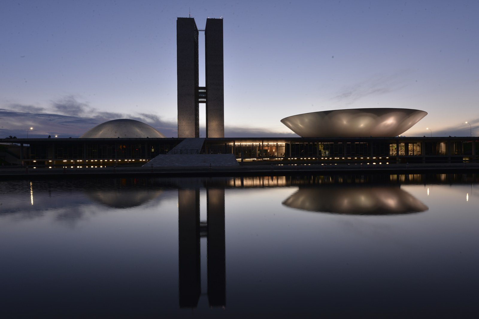 Congresso Nacional ao entardecer, com as torres, a cúpula do Senado e a da Câmara refletidas no espelho d'água, em Brasília (foto de arquivo)