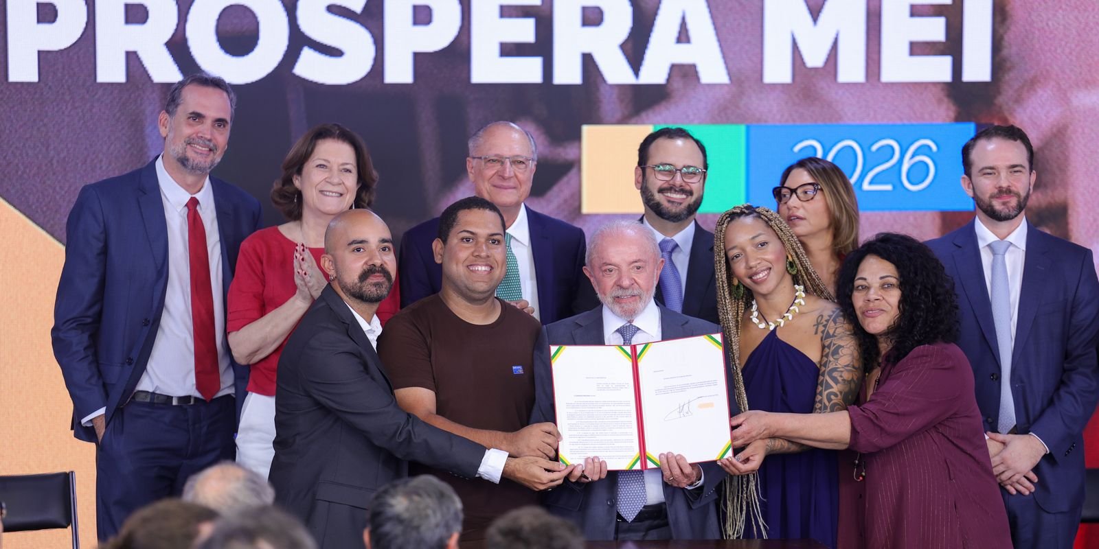 Lula exibe o projeto do pacote Prospera MEI, ao lado de microempreendedores e ministros, no Palácio do Planalto
