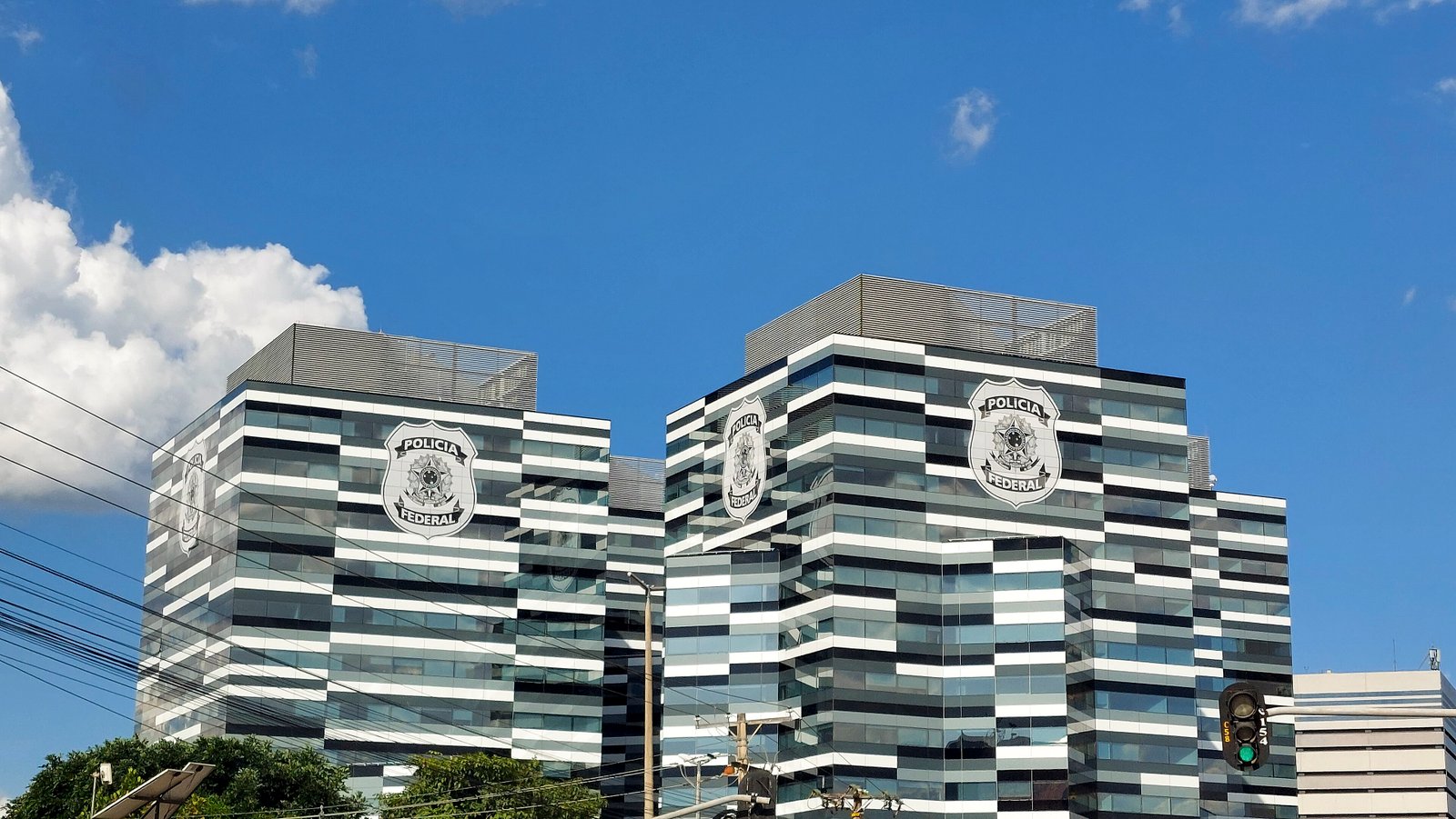 Fachada do edifício-sede da Polícia Federal, com o brasão da instituição nas duas torres