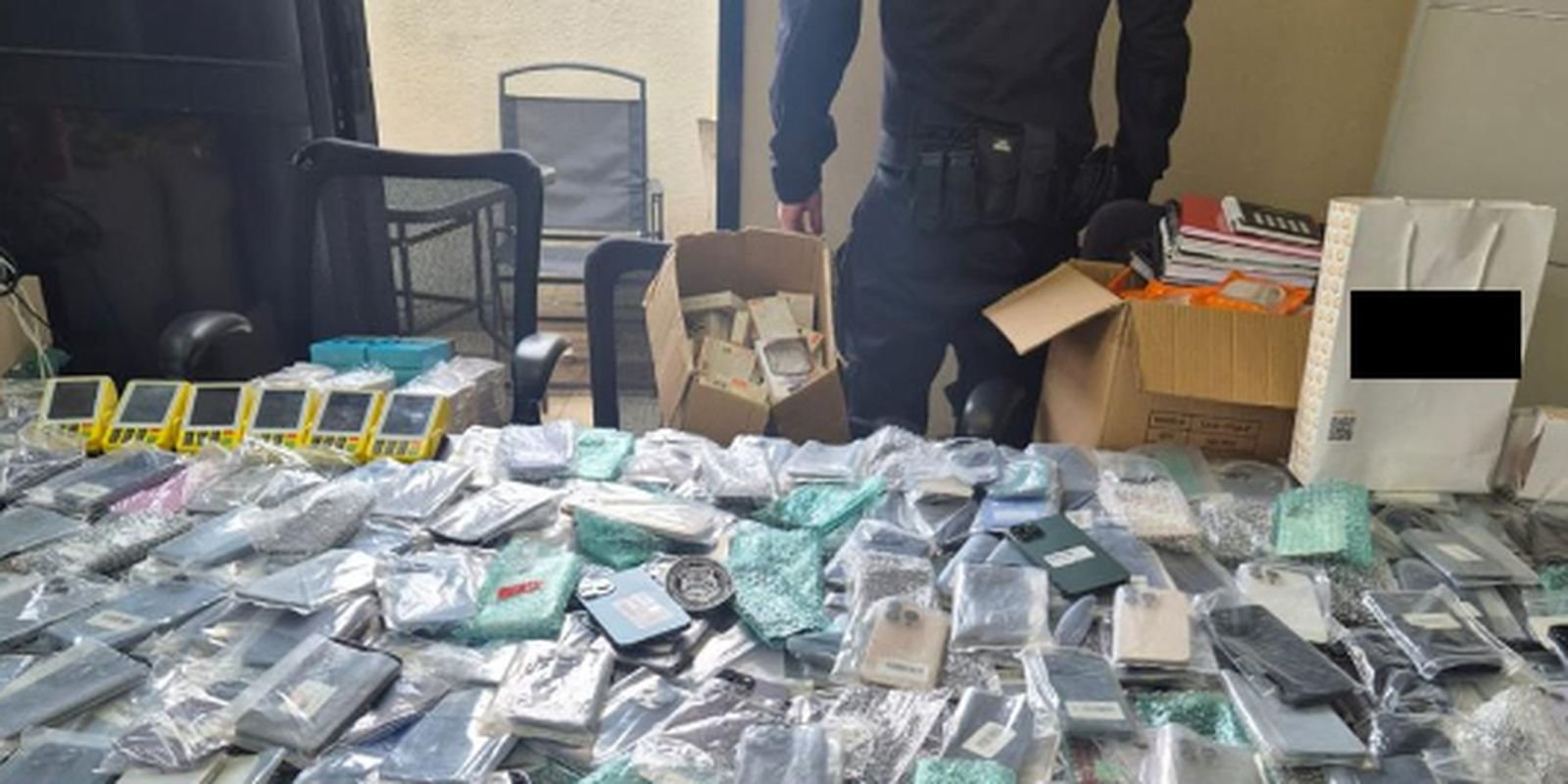 Mesa coberta de celulares e acessorios eletronicos apreendidos em operacao da Policia Federal