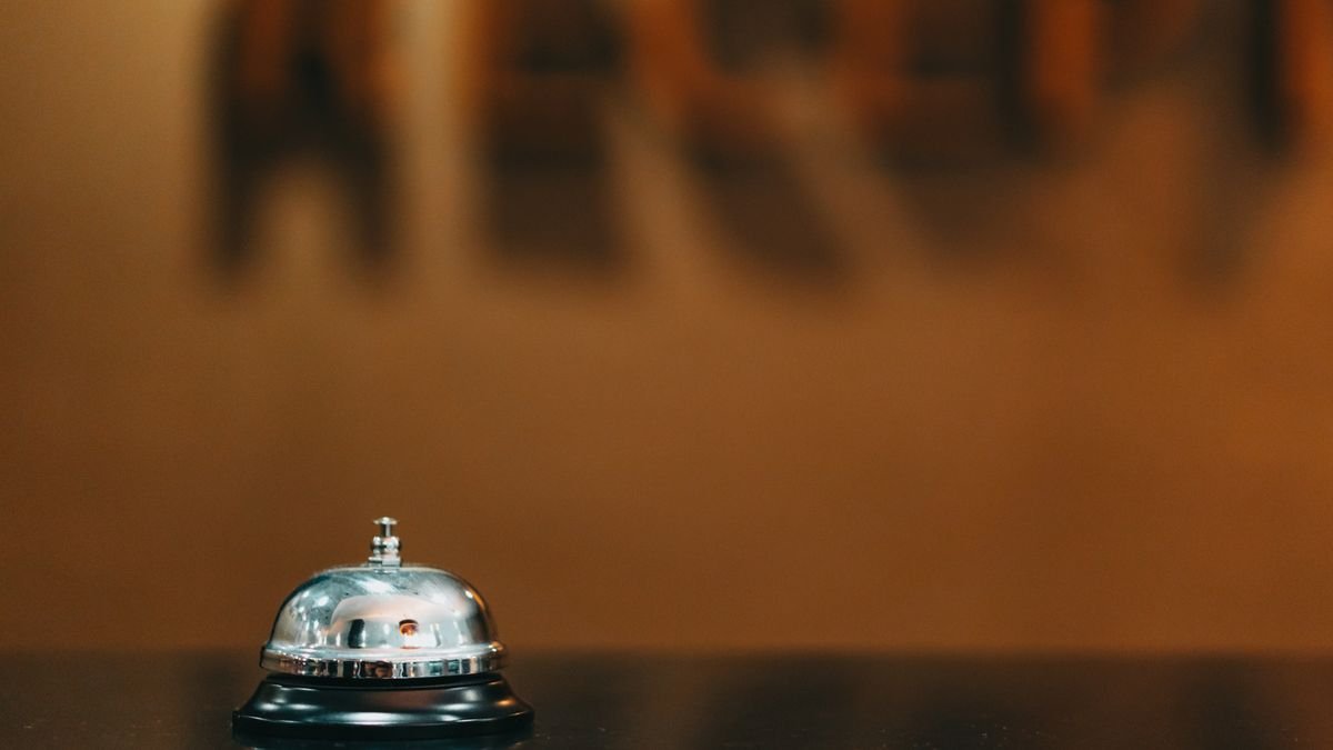 Sino metálico sobre o balcão de recepção de um hotel