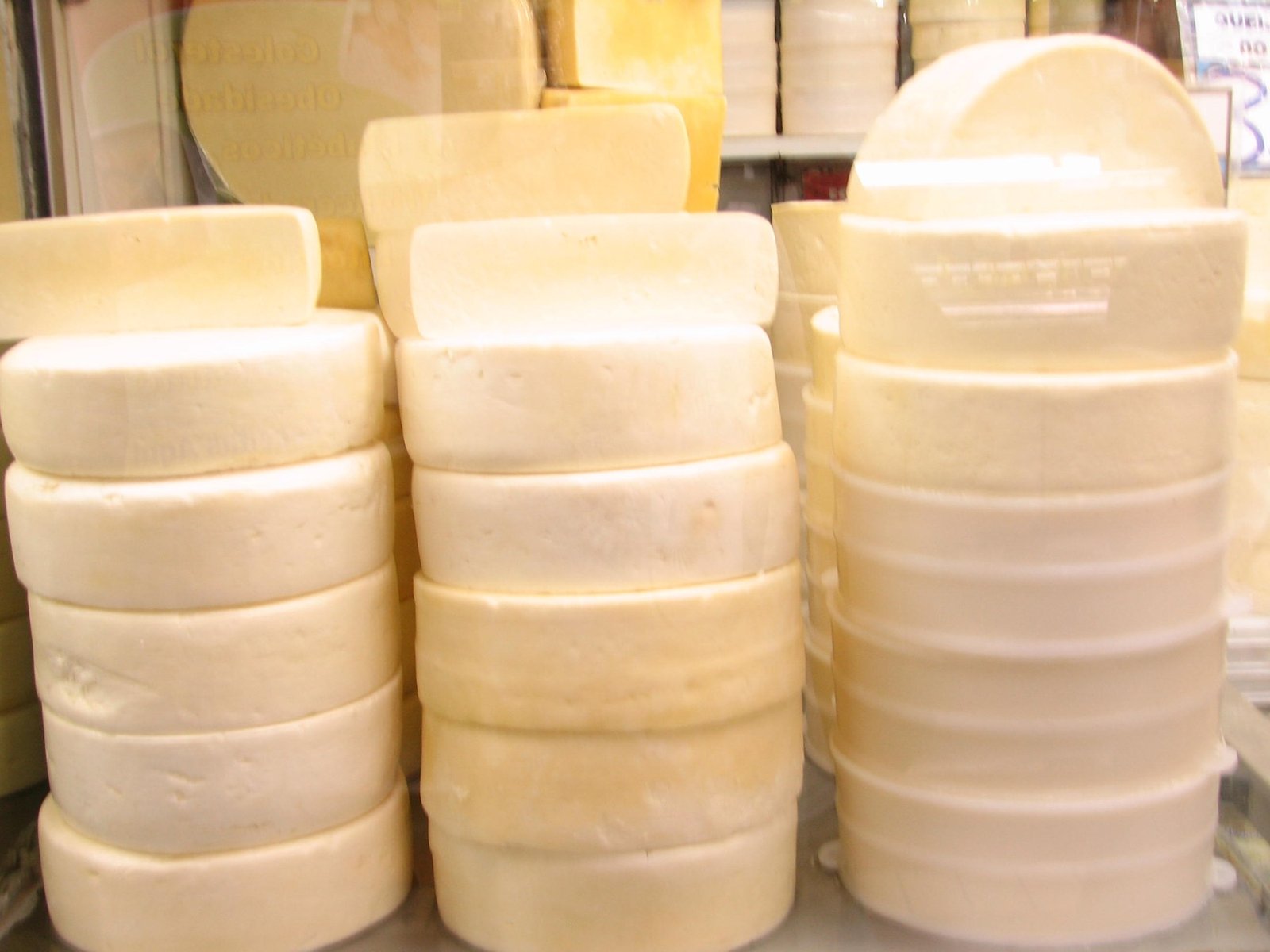 Pilhas de queijos artesanais de Minas Gerais em balcão refrigerado