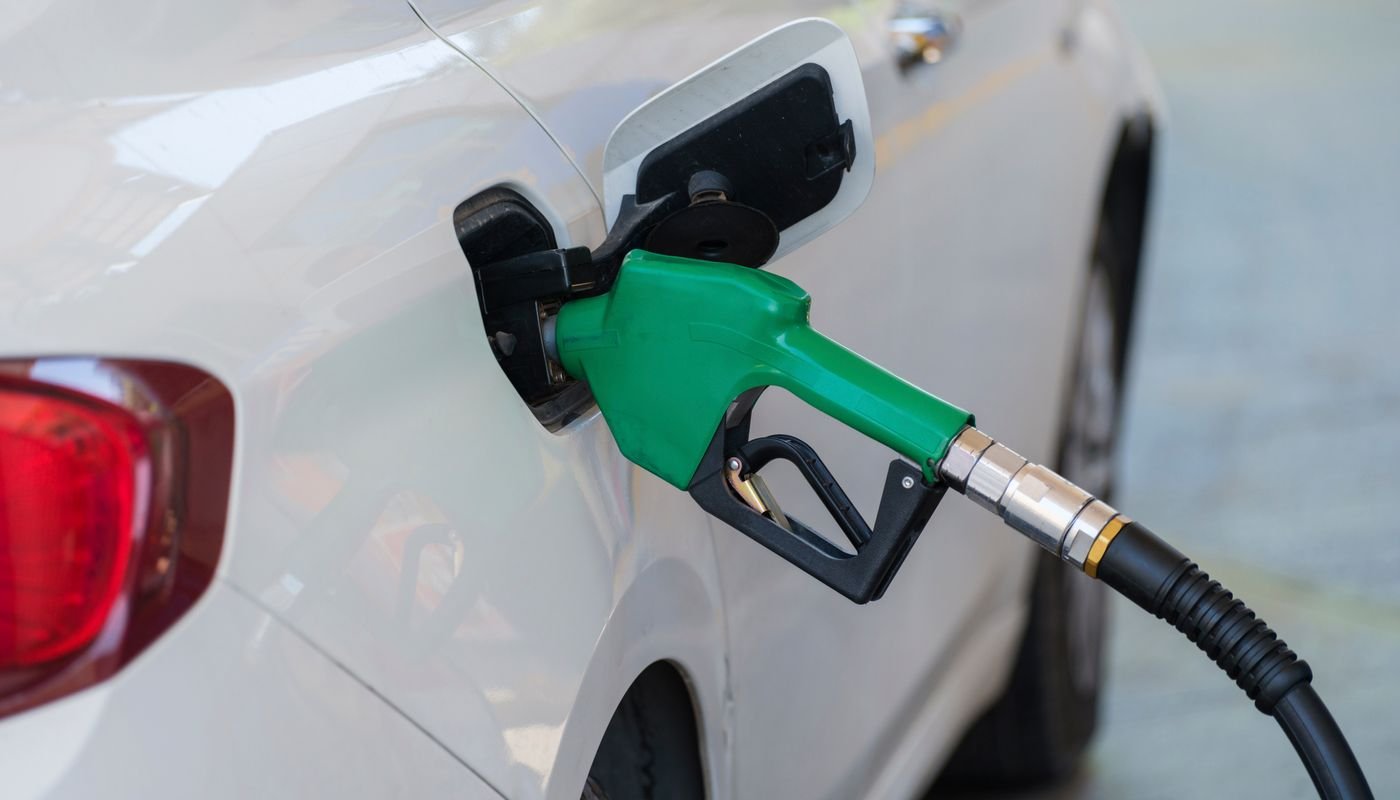 Bico de abastecimento verde inserido no tanque de um carro branco