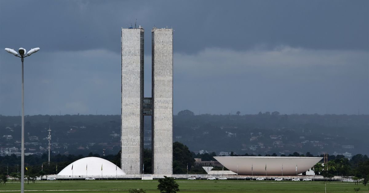 Congresso Nacional visto de longe sob céu carregado em Brasília